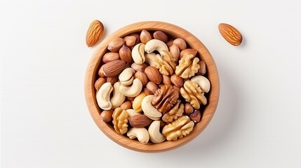 A wooden bowl containing a variety of mixed nuts is positioned on a white tabletop, captured from a top-down view.