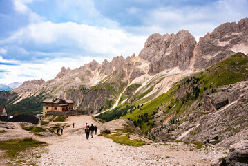 Fototapeta na wymiar Mountain hiking trail with people walking in Dolomite alps