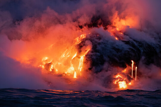 Detail of a lava coming from the volcano In Hawaii and flowing into the sea at night