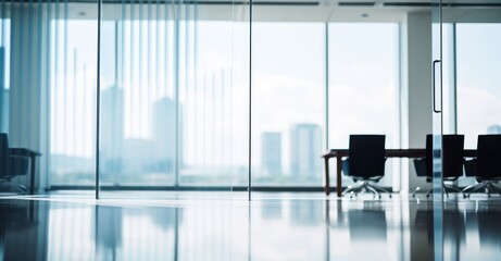 Empty modern office with glass partitions and blurred bokeh background, bathed in natural light.