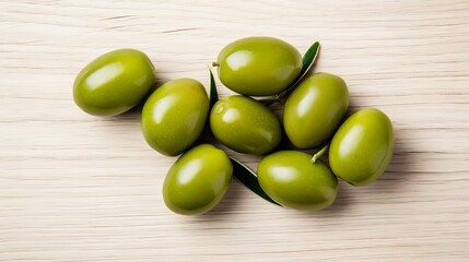 Delicious large green olives, accompanied by leaves, are isolated on a white background in this aerial view.