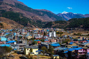 Fototapeta na wymiar Vibrant Townscape of Jumla with the Snow-Capped Himalayas in the Distance, Nepal