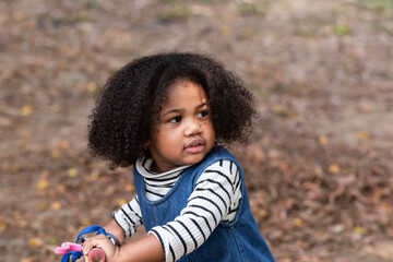 Adorable afro girl learning how to ride a bicycle, kid have fun, joy playing in park, preschool...