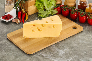 Swiss Maasdam cheese triangle over board