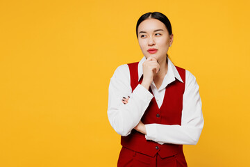Young minded corporate lawyer employee business woman of Asian ethnicity wear formal red vest shirt work at office prop up chin look aside isolated on plain yellow background studio. Career concept.