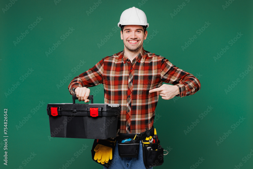 Wall mural young employee laborer handyman man wear red shirt hardhat hat work hold point on toolbox isolated o