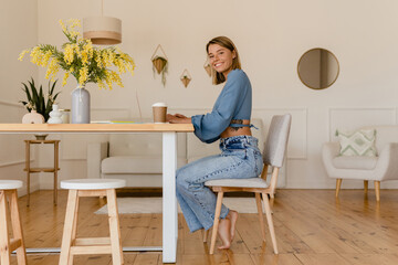 young pretty stylish woman working remote at home at table workplace, student education