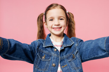 Close up little child kid girl 7-8 years old wears denim shirt have fun do selfie shot on mobile cell phone isolated on plain pastel light pink background. Mother's Day love family lifestyle concept.