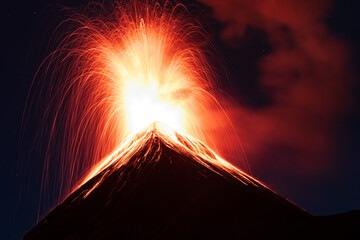 Volcano fuego erupting with a fire explosion of orange lava or magma at night with long exposure in...