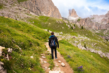 Hiker walking on mountain hiking trail in Dolomite alps