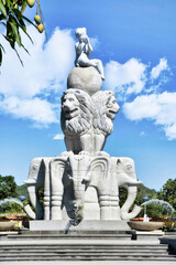 Fototapeta premium Nha trang, Long Son Pagoda (Vietnam) Fountain with statues of elephants and lions in the park with tropical flowers and palm trees under sunlight
