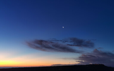 Il giorno e la notte si incontrano all’alba nel cielo sopra il mare 