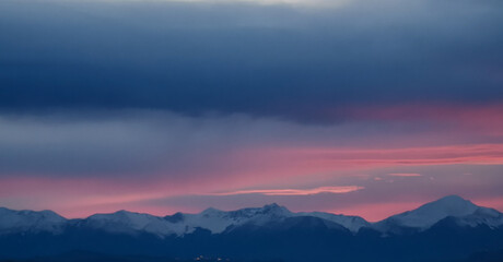 Tramonto rosa sopra le cime dei monti innevate