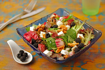 Mixed salad with cheese and blackberries.