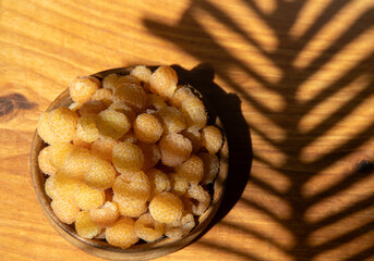 Yellow raspberries in a wooden bowl on the table. Summer berries background. Vitamin food, berry harvest. Healthy nutrition.