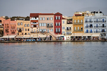 Obraz premium Taverns, historic buildings and crowds of tourists in the port of Chania on the island of Crete