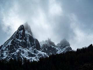 Picos nevados con nubes bajas en alta montaña