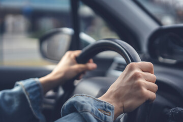 Tense hands of a female driver on the steering wheel in a car. Stress while driving a car - 754865321
