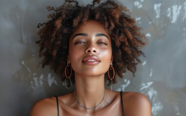 A multiracial woman with curly hair is wearing large hoop earrings