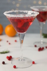 Tasty cranberry cocktail in glasses on light background, closeup