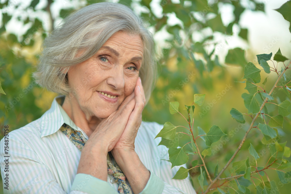 Wall mural Portrait of happy senior woman posing at forest