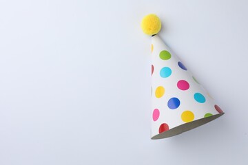 One beautiful party hat on light background, top view. Space for text
