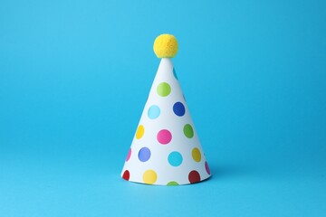 Colorful party hat on light blue background