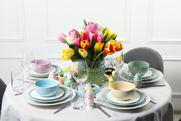 Easter celebration. Festive table setting with beautiful flowers and painted eggs