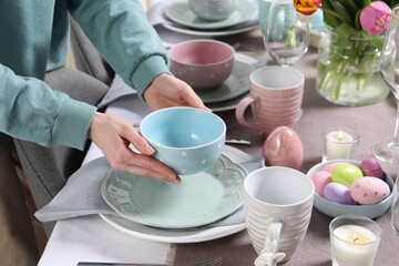 Woman setting table for festive Easter dinner at home, closeup