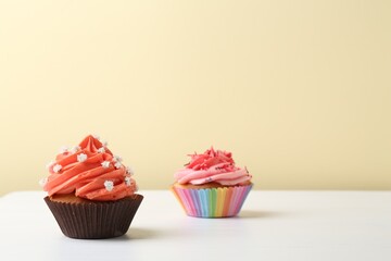 Delicious cupcake with bright cream on white wooden table. Space for text