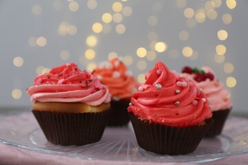 Delicious cupcakes with pink cream on table, closeup