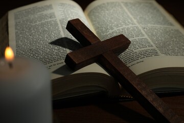 Cross, Bible and church candle on wooden table