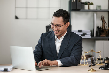 Obraz premium Asian man Lawyer Or Judge working at his office with court hammer and laptop on the table Legal And Justice.