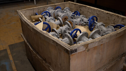 Close-up of valves in a box at the factory. Production and shipment of valves and metal pipes....
