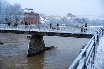 Snowfall in the city . The old bridge is covered with snow. 