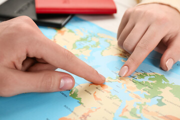 Fototapeta na wymiar Man and woman planning their honeymoon trip with world map at white wooden table, closeup
