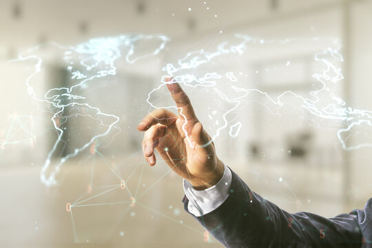 Double exposure of man hand working with abstract digital world map hologram on blurred office background, big data and blockchain concept