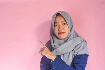 Image of happy young business woman posing isolated above. Wearing batik clothes and hijab - Powered by Adobe