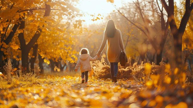Happy family on autumn walk! Mother and daughter walking in the Park and enjoying the beautiful autumn nature.