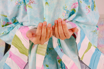 Muslim woman is Praying at home. Close-up hand praying gesture.