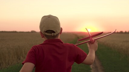 hands boy child kid airplane background setting sun. Child Kid runs across field embodying dream...