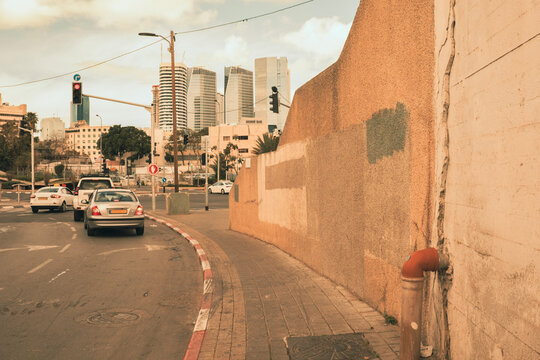 Urban view of Levanda Street, Tel Aviv, with warm hues reflecting Hamsin weather, blending traditional and modern architecture. Taxis on the cross road