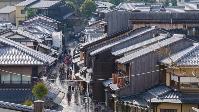 timelapse video of crowded tourisrs people on Sanneizaka swalking treet surrounded by the typical Kyoto townhouses or machiya buildings both side near Kiyomizudera temple