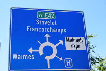 blue traffic circle sign in Malmedy, Belgium - obrazy, fototapety, plakaty
