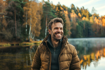 Man in  who exudes happiness and a sense of feeling truly alive in a beautiful natural park near a lake