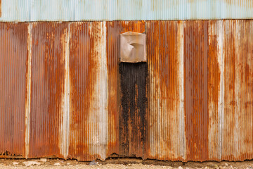 茶色く錆びた金属の波板の壁