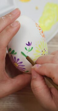 Happy Easter holiday.Close-up shot of a Mother's hands painting easter eggs,Coloring eggs top view,family traditions 