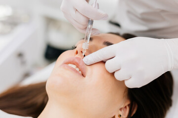 Lip augmentation concept. Unrecognizable female receiving hyaluronic acid injection. The doctor...