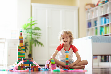 Child playing with toy blocks. Toys for kids.