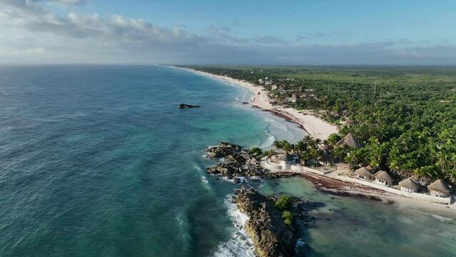 Enjoy a breathtaking view of Tulum beach at sunset as vibrant colors paint the landscape from an aerial perspective in this captivating video.